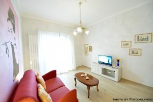 ein Wohnzimmer mit einem roten Sofa und einem Tisch in der Unterkunft IzzHome La Signorina in Rom