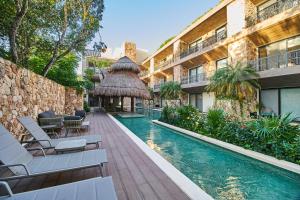 un complejo con piscina y un edificio en Beautiful Luxury Poolside Retreat in Aldea Zama Tulum en Tulum