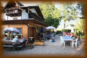 a group of people sitting at tables outside of a building at Gasthof zum Schlern in Fiè