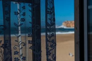 纳扎雷DonaCamó Charming House的享有海滩景致的窗户。
