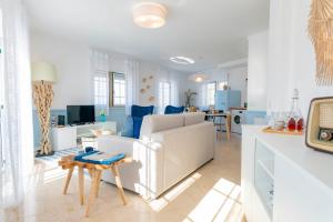 a white living room with a couch and a table at DonaCamó Charming House in Nazaré