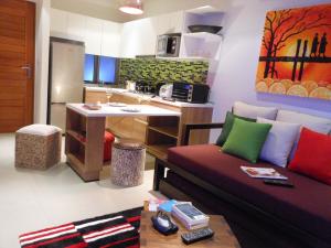 a living room with a couch and a kitchen at Top Floor, One-Bedroom Apartment in Phuket