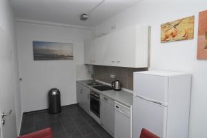 a kitchen with white cabinets and a refrigerator at City Apartment Vohwinkel in Gelsenkirchen