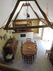 an attic dining room with a table and chairs at Gîte de la pouvellerie in Fossemagne