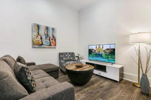 a living room with a couch and a tv at 1 and 2 BR Private Condos Steps Away From French Quarter in New Orleans +61 photos