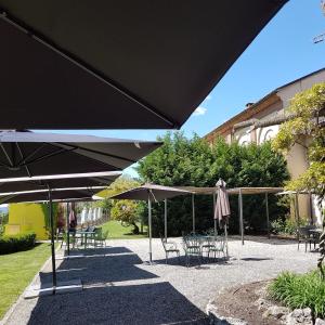 un grupo de mesas y sillas con sombrillas en Borgo Ramezzana Country House, en Trino