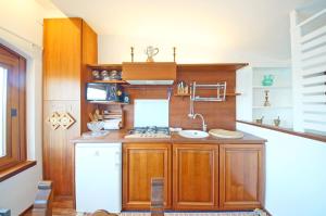 eine Küche mit Holzschränken und einem weißen Kühlschrank in der Unterkunft DolceVita Apartments N 453 Canal View in Venedig