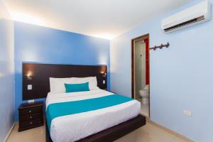 a bedroom with a bed and a lamp on the wall at Azuán Suites Hotel By GH Suites in Cartagena de Indias