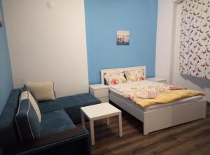 a small bedroom with a bed and a couch at Casablanca City in Varna City