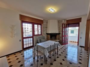 a dining room with a table and chairs and a fireplace at Villa Boito in Marina di Pescoluse +15 photos