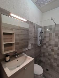 a bathroom with a sink and a toilet and a mirror at Villa Boito in Marina di Pescoluse