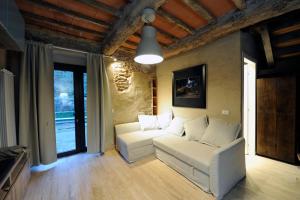 a living room with a white couch and a window at Incantevole casa sul fiume, Relax e Natura ai piedi della Alpi Apuane in Massa