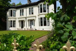 a large white house with a yard at Number 10 Hotel in Glasgow