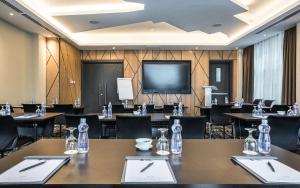 a conference room with tables and chairs and a projection screen at Best Western Plus Westlands in Nairobi