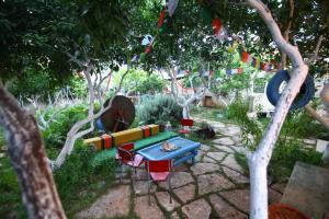 un jardín con mesa, sillas y banderas en Timbuktu Hostel en San Vito lo Capo
