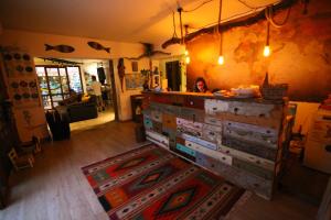 a woman is sitting in a room with a dresser at Timbuktu Hostel in San Vito lo Capo