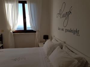 a bedroom with a bed with white sheets and a window at Hotel Ristorante Radar in Carrara
