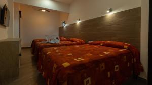 two beds in a hotel room with two bedsvisor at Hotel Galería del Ángel in Santa Cruz Huatulco