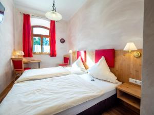 a bedroom with two beds and a desk and a window at Kleinkunstbühne Zur Post beim John in Obing in Obing