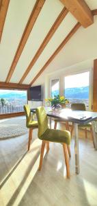 a dining room with a table and green chairs at Sanosueno 1 in Sonthofen