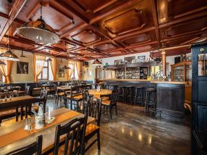 a restaurant with wooden tables and chairs and a bar at Kleinkunstbühne Zur Post beim John in Obing in Obing