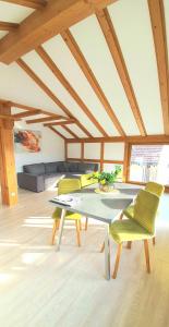 a living room with a table and yellow chairs at Sanosueno 1 in Sonthofen