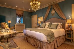 a bedroom with a large bed and a chandelier at Kasteel van Ordingen in Sint-Truiden