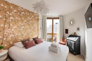 sypialnia z dużym białym łóżkiem i pianinem w obiekcie ANGELE by Cocoonr w mieście Rennes