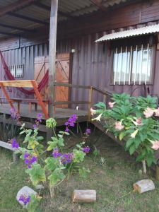 un banco y flores delante de una casa en Sonidos del Mar, en Punta del Diablo