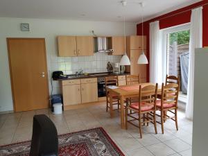 a kitchen with a table and chairs and a dining room at Ferienwohnung Pewsum in Krummhörn