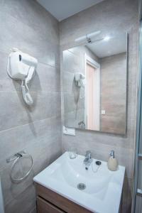 ein Badezimmer mit einem weißen Waschbecken und einem Spiegel in der Unterkunft Apartamento Dúplex Casco Antiguo AT Postigo 20 in Cáceres
