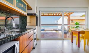 a kitchen with a table and a view of the ocean at Pousada Residencial La Caracola in Florianópolis