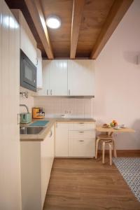 eine Küche mit weißen Schränken und einer Holzdecke in der Unterkunft Apartamento Dúplex Casco Antiguo AT Postigo 20 in Cáceres