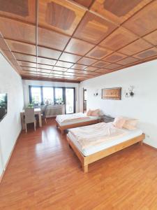 two beds in a large room with a wooden ceiling at Gasthaus Zum Alten Euler in Erzhausen