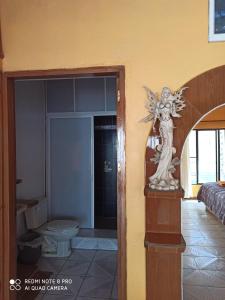 un baño con una estatua de un ángel en una habitación en Castillo del Rey en Valle de Bravo