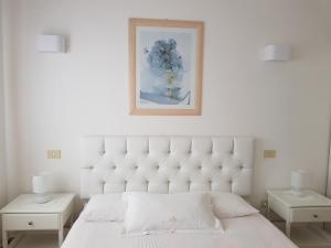 a bedroom with a white bed with two tables and a picture at Hotel Ristorante Radar in Carrara +159 photos