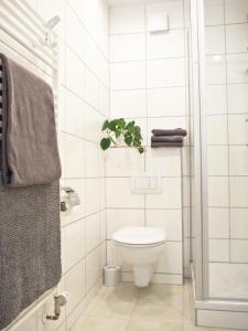 a white bathroom with a toilet and a plant at Gasthaus Zum Alten Euler in Erzhausen