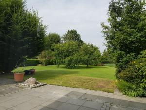 a garden with a large yard with trees and grass at Ferienwohnung Pewsum in Krummhörn