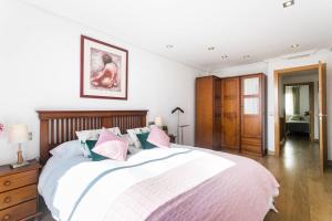 ein Schlafzimmer mit einem großen Bett mit rosa und blauen Kissen in der Unterkunft Bungalow Altea junto al casco antiguo, piscina y barbacoa in Altea + 44 Fotos