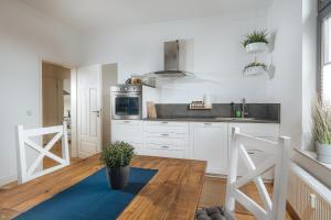 uma cozinha com armários brancos e um tapete azul em Große Koje mit Terrasse em Rostock