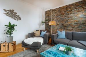 ein Wohnzimmer mit Sofa und Ziegelwand in der Unterkunft Große Koje mit Terrasse in Rostock