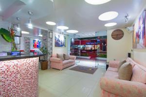 un hall de stockage avec des chaises roses et un comptoir dans l'établissement Hotel Marina Suites By GEH Suites, à Carthagène des Indes