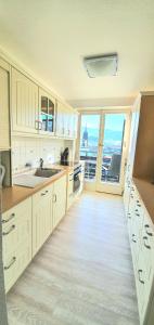 a kitchen with white cabinets and a large window at Sanosueno 2 in Sonthofen