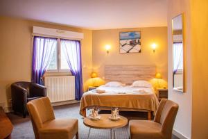 a hotel room with a bed and two chairs at Hotel du Port et des Bains in Saint-Valery-sur-Somme