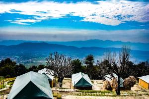 a group of tents with mountains in the background at CBB - Camp Bir Billing in Bīr