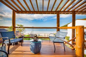 eine Terrasse mit Stühlen und Strandblick in der Unterkunft Pousada Residencial La Caracola in Florianópolis