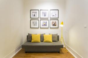 a living room with a gray couch with yellow pillows at Restauradores by Central Hill Apartments in Lisbon +43 photos