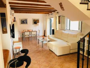 een woonkamer met een witte bank en een tafel bij Villas2meet in Cala Romantica