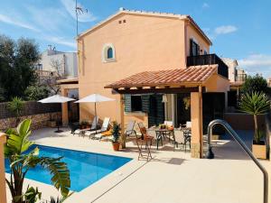 a house with a swimming pool and a patio at Villas2meet in Cala Romantica