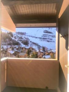 ein Fenster in einem Haus mit Bergblick in der Unterkunft Boost Your Immo Duplex Les Deux Alpes 272 in Les Deux Alpes